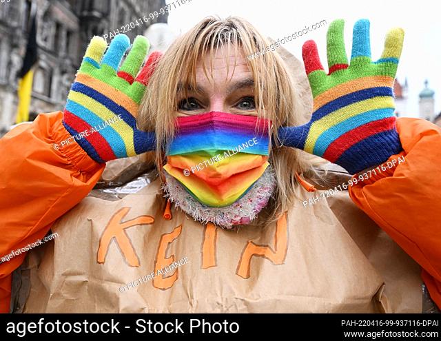 16 April 2022, Munich: A participant wears gloves and a mouth-nose protector in Peace colors at the Easter March in Munich