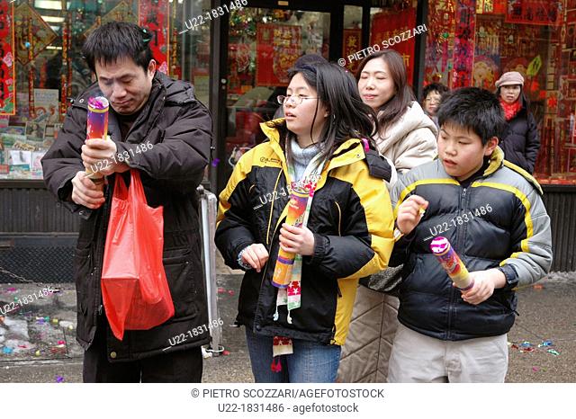 New York City, Chinese family commemorating the New Chinese Lunar Year in Chinatown with fireworks, Manhattan