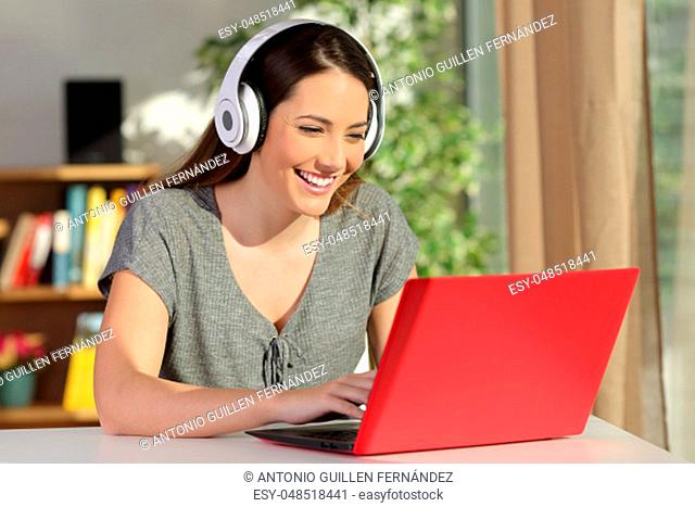 Girl e-learning with a laptop and headphones at home