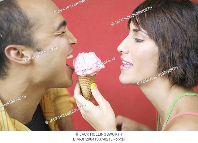 Profile view of couple sharing ice cream cone