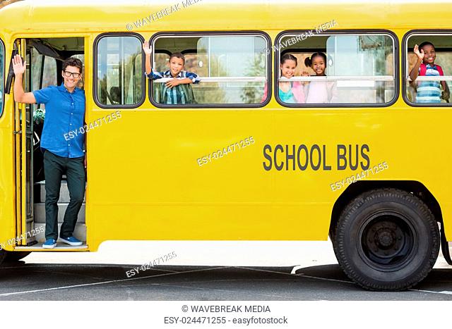 Portrait of teacher and kids waving hand from bus