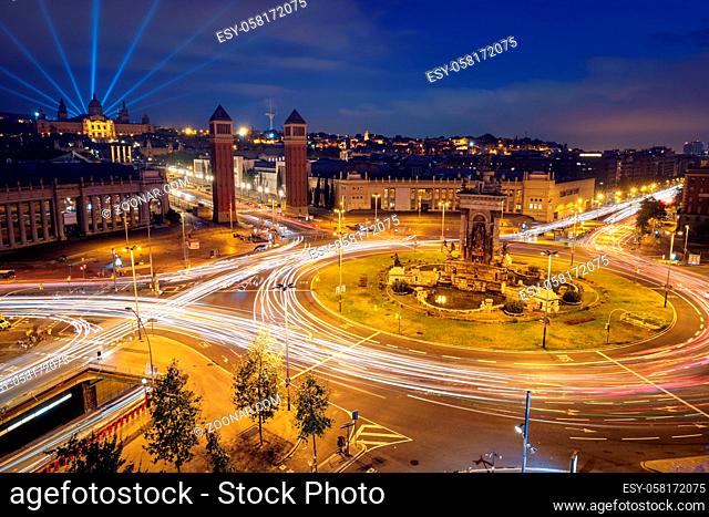 View Placa d'Espanya, Plaza de Espana, the Spanish Square in Barcelona, Catalonia, Spain with city traffic in the evening blue hour with light trails