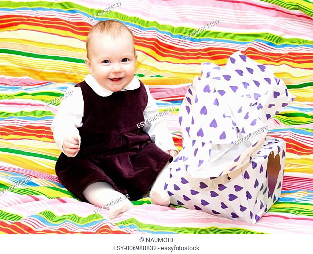 Happy eight month baby girl with wrapped gift