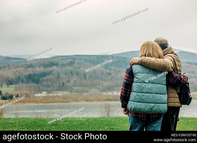 Senior couple embracing in front of Sudetes mountains