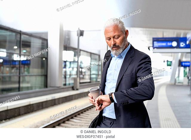 Mature businessman at the station platform checking the time