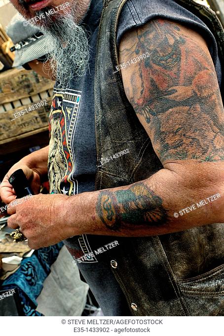 An old motorcyclist rider's tattoos have not aged well