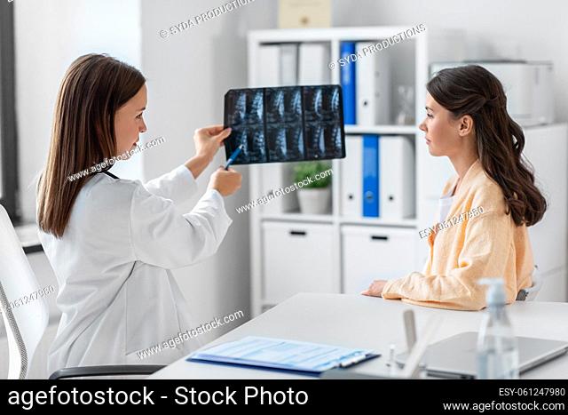 doctor showing x-ray image to woman at hospital