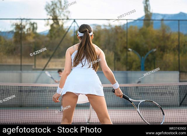 Woman waiting for return playing tennis with her partner