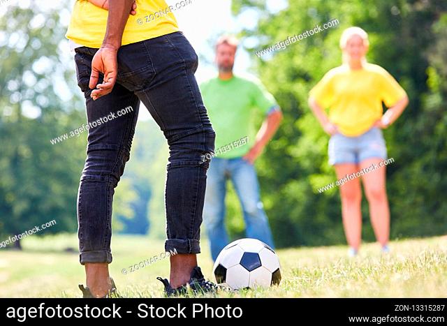 Junge Leute spielen Fußball auf einer Wiese auf einem Workshop oder einem Sportfest