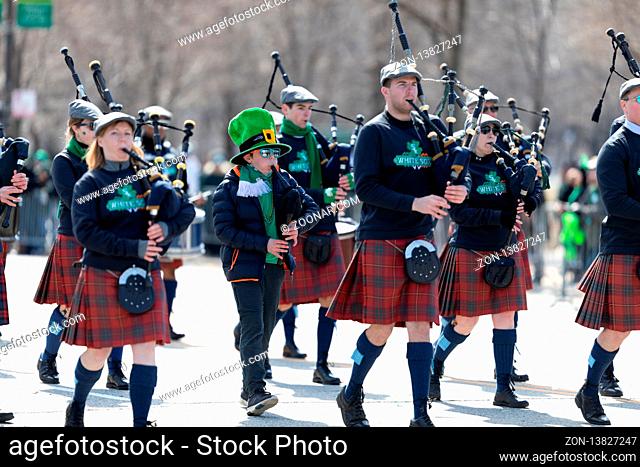 Chicago, Illinois, USA - March 16, 2019: St. Patrick's Day Parade, Bagpipe band wearing White Sox shirts marching down Columbus Drive during the parade