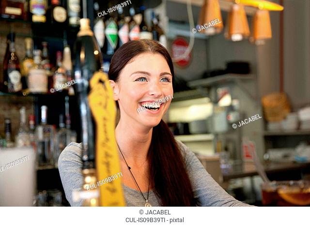 Bartender serving drinks in pub, London
