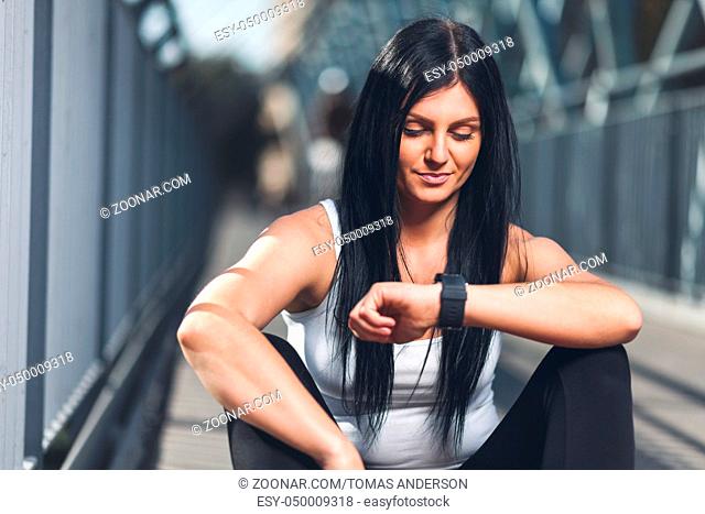 City workout. Beautiful young woman with a smartwatch training in an urban setting
