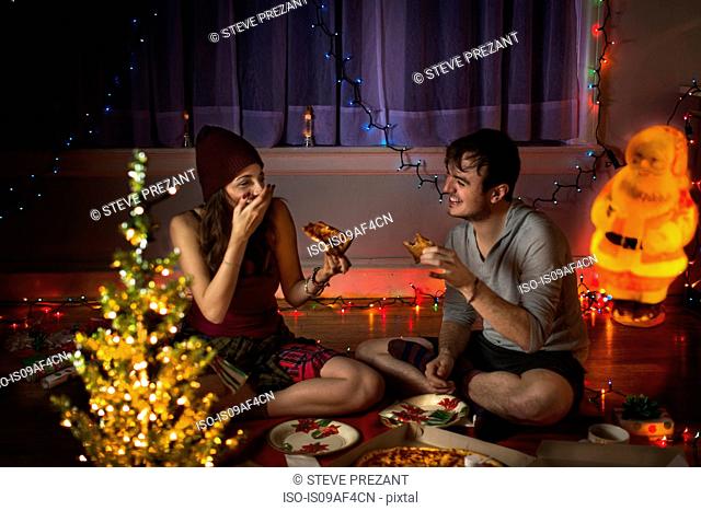 Young couple enjoying pizza at christmas
