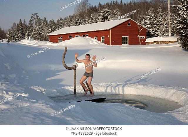Young Happy Man by Ice Hole in Väike Trommi Tourism Farm, Valga County, Estonia