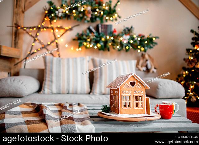 Homemade gingerbread house on background room decorated for Christmas