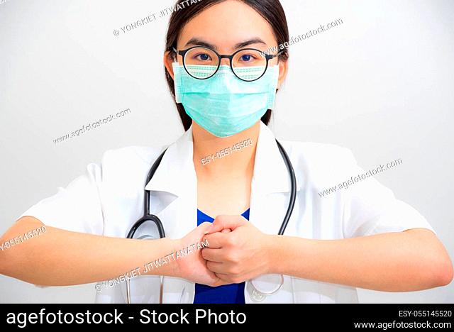 Portrait beautiful Asian woman doctor with stethoscope and mask to protect Corona Virus clasp hand gesture of beg for help cooperation