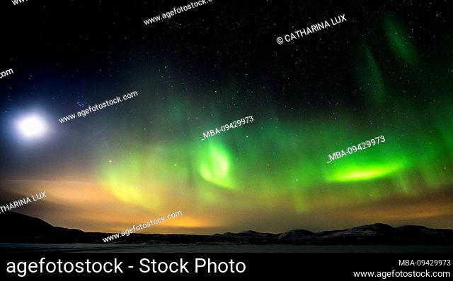 Lapland, snowy mountain landscape, northern lights and moonlight