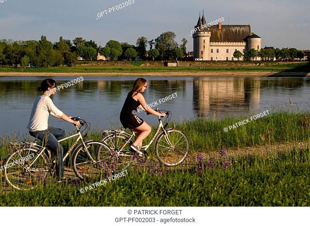 YOUNG WOMEN CYCLING ALONG THE 'LOIRE A VELO' CYCLING ITINERARY IN FRONT OF THE CHATEAU OF SULLY-SUR-LOIRE, SAINT-PERE-SUR-LOIRE, LOIRET 45, FRANCE