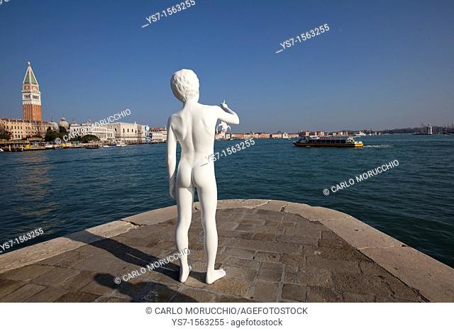 The sculpture boy with frog by Charles Ray in front of Punta della Dogana and St. Mark's bell tower in the background, Venice, Italy, Europe