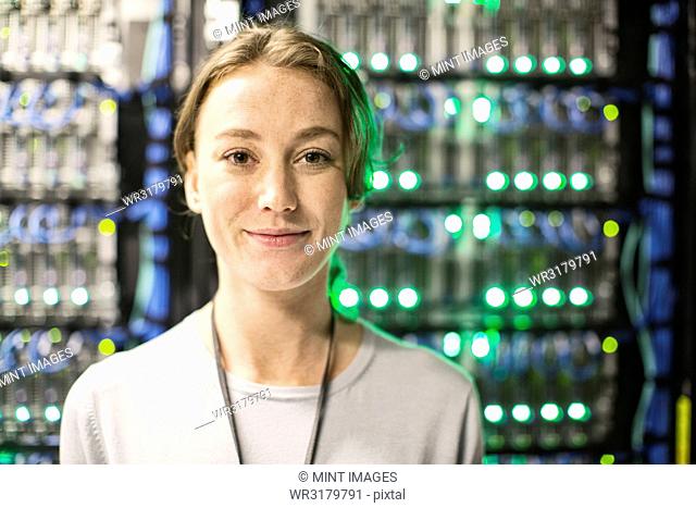 Caucasian woman technician in a large computer server farm