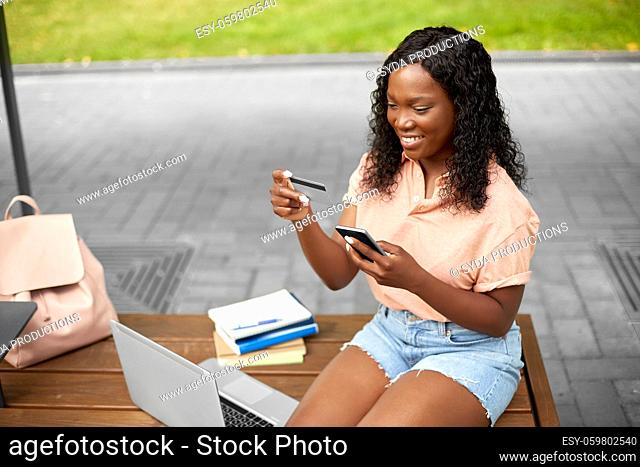 student girl with smartphone and credit card
