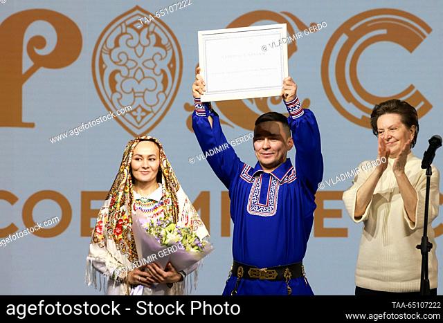 RUSSIA, MOSCOW - NOVEMBER 23, 2023: Bride Tatyana and groom Vitaly receive a certificate for a snowmobile as Natalya Komarova (L-R)