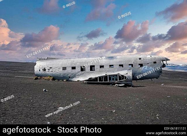 Abandoned damaged aircraft wreck at black sand beach. Broken military airplane in Solheimasandur. Famous tourist attraction against cloudy sky during sunset