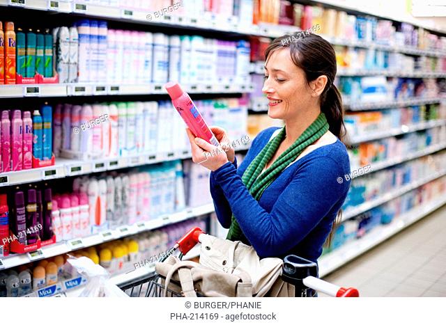 Woman shopping in body care section in supermarket