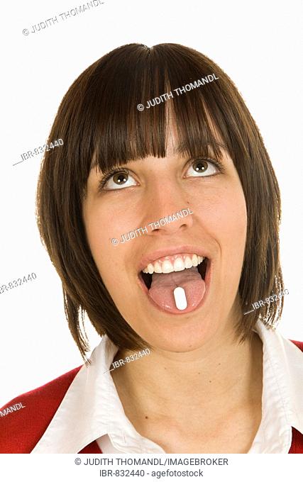 20-year-old woman with a tablet on her tounge