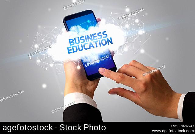 Female hand touching smartphone with BUSINESS EDUCATION inscription, cloud business concept