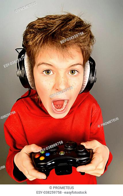 Funny boy gamer with a controller and headphones. Studio shot