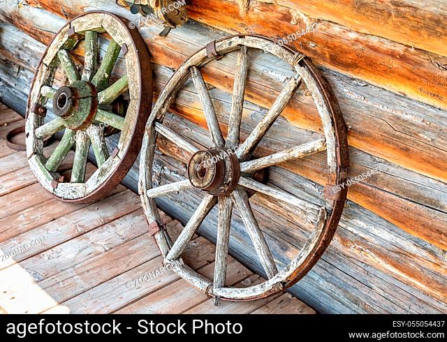 Old wooden broken wagon wheels in the abandoned village in summer day