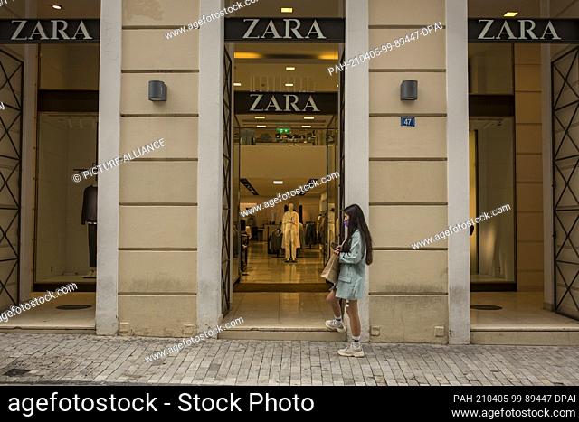 05 April 2021, Greece, Athen: A young woman waits outside a clothing store to enter. From Monday, 05.04.2021, shops in large parts of Greece will be allowed to...