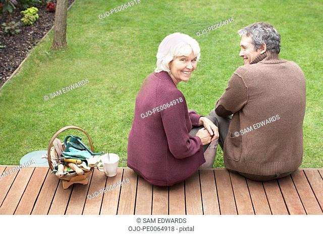 Couple sitting on backyard deck