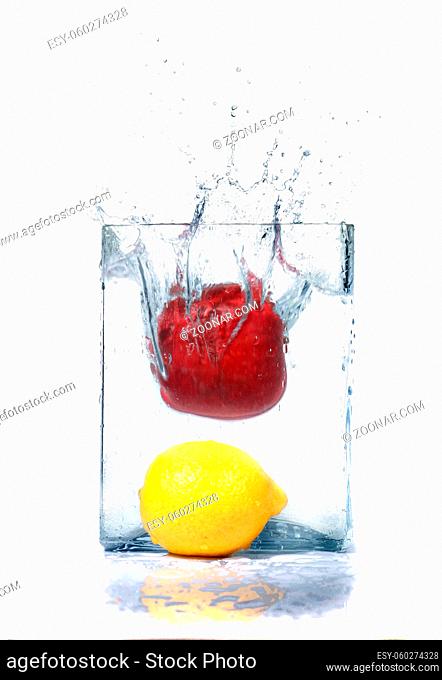 apple and lemon in water and splashes is isolated