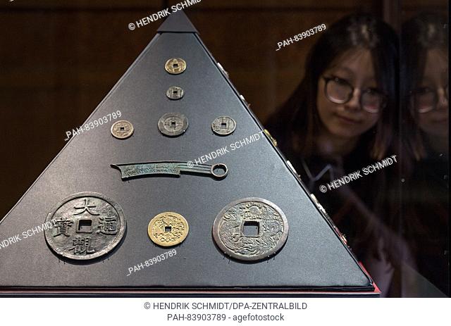 A woman looks at Chinese amulets (Joachim Krueger collection) from the Zhou and Ming dynasties in the historical rooms of the Moritzburg Art Museum in...