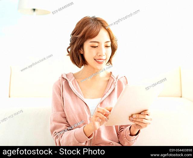 Happy casual beautiful woman working on tablet at home