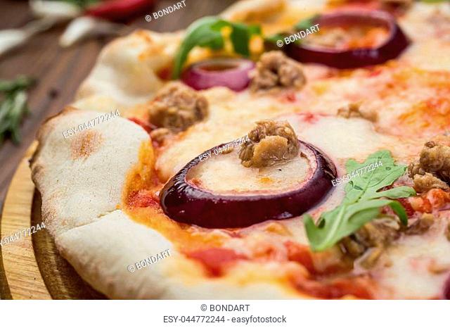 Minced meat tomato red onion pizza on a wood background