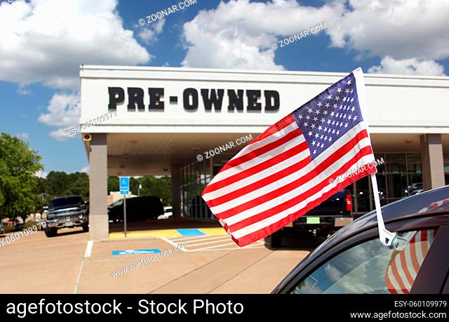 Pre-Owned Car Dealership with American Flag