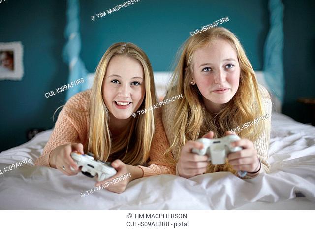 Two teenage girls playing on computer game in bedroom