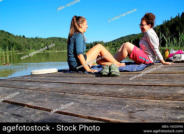 two young women at breakfast at the lake, picnic, shoes, blanket, europe, germany, upper bavaria, werdenfelser land, mittenwald, ferchensee