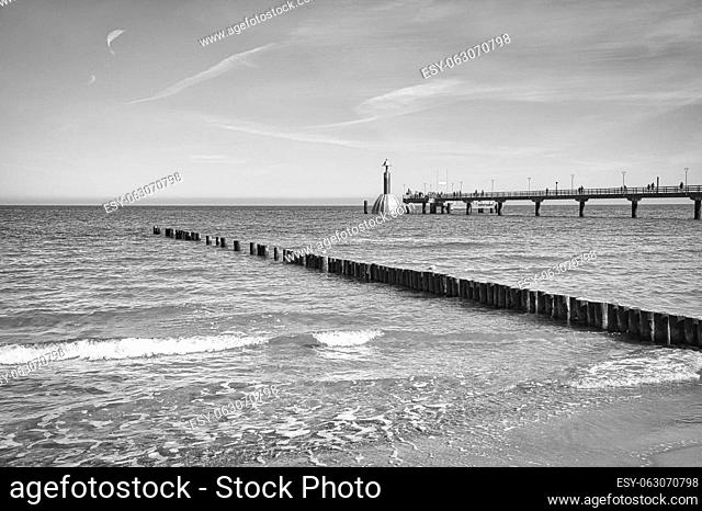 the pier in Zingst on the Baltic Sea, with a long exposure in black and white. a seaside attraction in this region