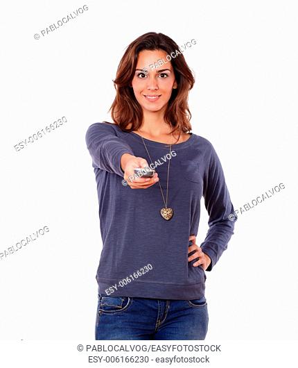 Portrait of a gorgeous young woman pointing the remote control on white background