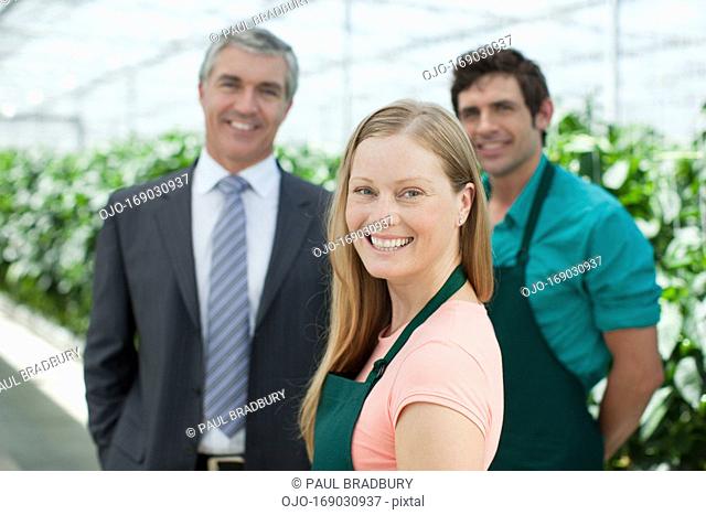 Businessman and workers in greenhouse