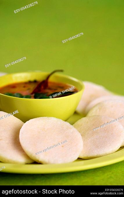 Idli with Sambar in bowl on green background, Indian Dish : south Indian favourite food rava idli or semolina idly or rava idly