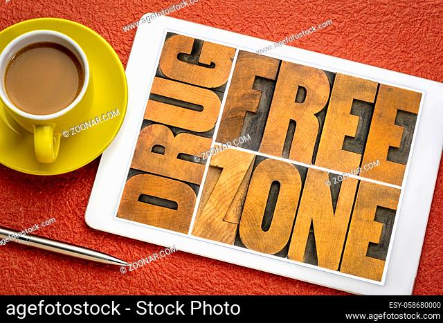 drug free zone word abstract in vintage letterpress wood type on a digital tablet with a cup of coffee