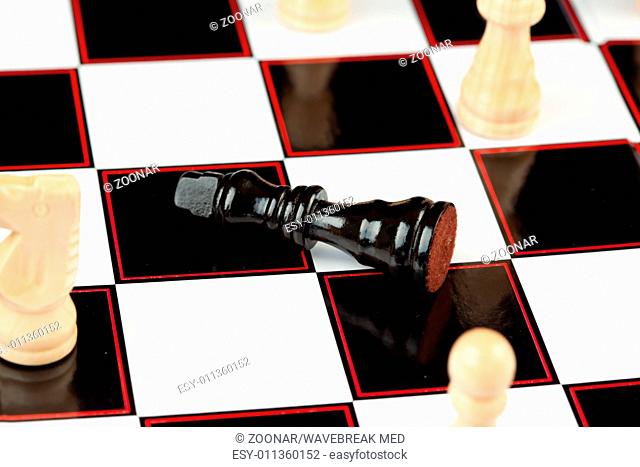 Black chessman lying