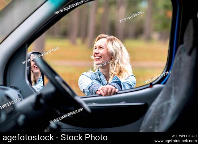 Cheerful woman seen from camper van window
