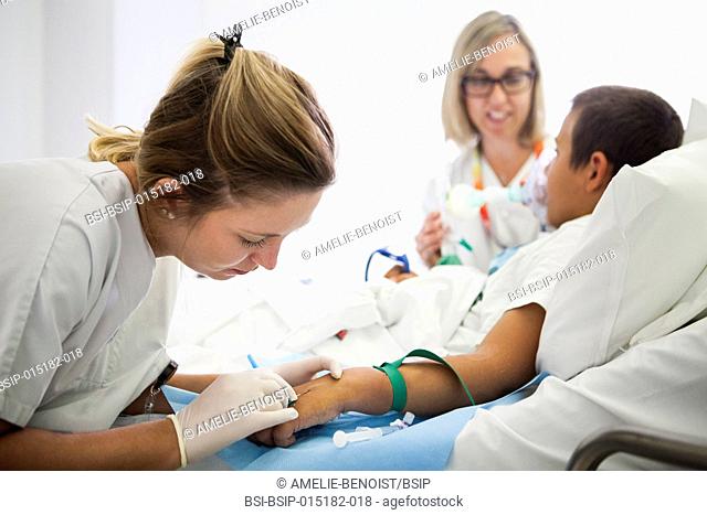 Reportage in the pediatric unit in a hospital in Haute-Savoie, France. A nurse places a catheter while another holds a mask releasing Nitronox (a mix of gas and...