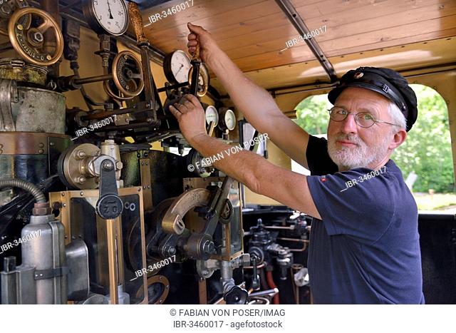 Bernd Roschach, train driver chairman of the Acher Valley Railway Society, standing in a locomotive of the Acher Valley Railway from 1928 in Ottenhoefen station